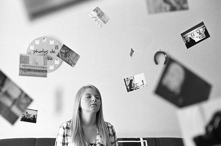 Woman sitting surrounded by pictures.