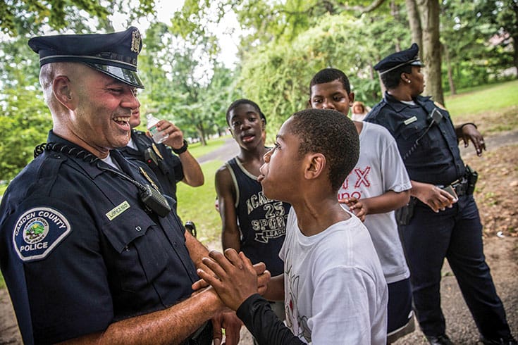 A cop laughs with children.