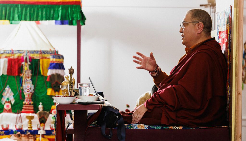 Side profile photo of Shenchen Rabjam Rinpoche presenting to an audience.