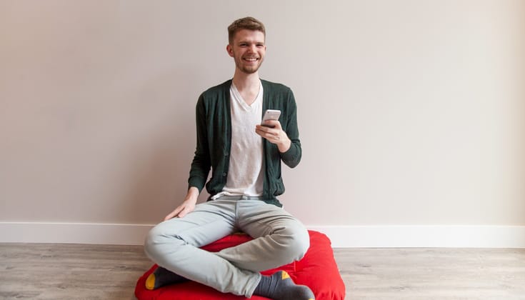 Meditator holding an iPhone.